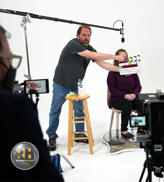 A production crew member slates a scene at a cyclorama studio in Denver.